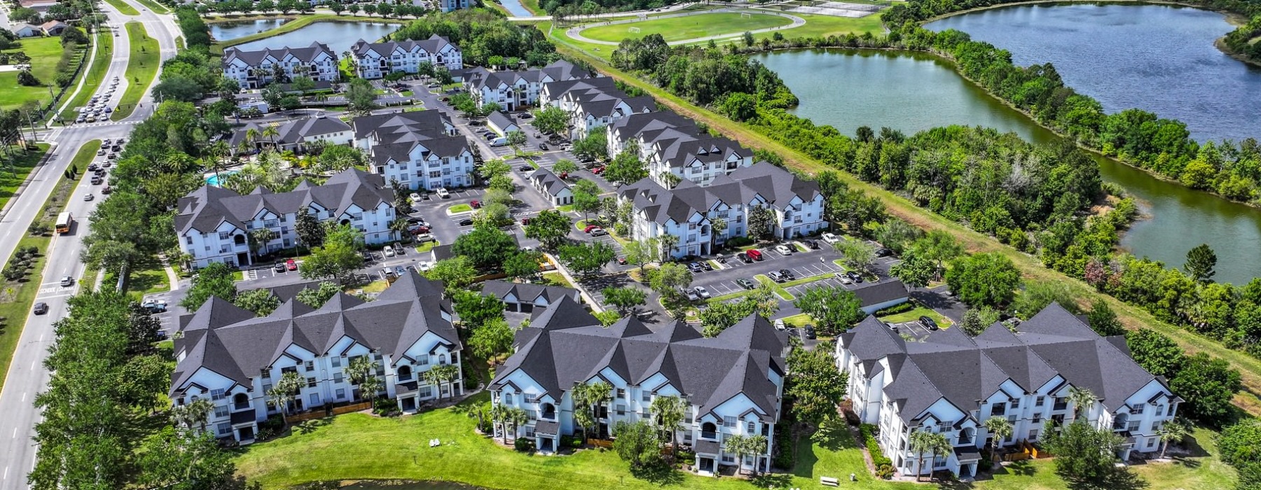 aerial view of a community next to a road and a pond