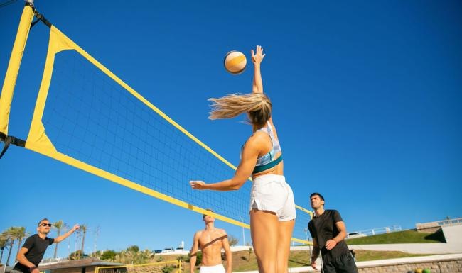 a person jumping to catch a volleyball
