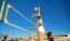a person jumping to catch a volleyball